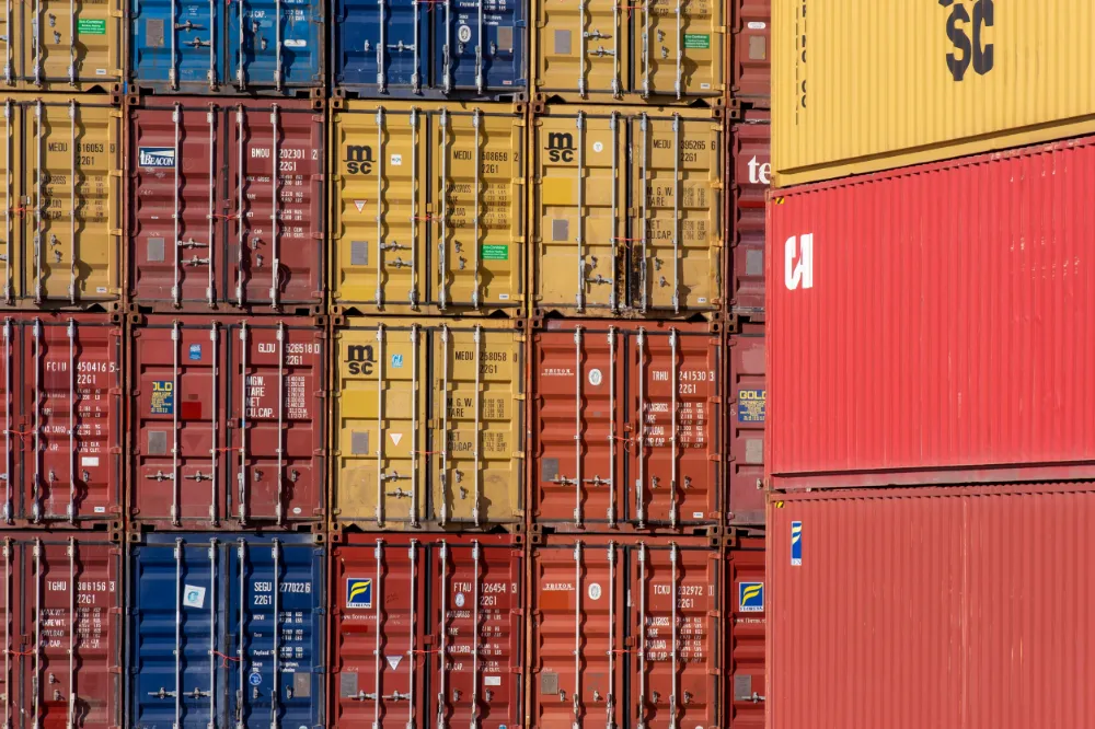 Brukte containere stablet i flere høyder på depot